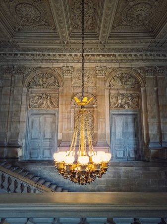 Téléchargez les photos : Détails architecturaux d'un escalier, d'une salle ornée et d'un lustre vintage lumineux accrochés au plafond, château de Versailles, France - en image libre de droit