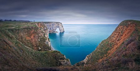 Photo for Sightseeing panoramic view to the Porte d'Aval natural arch cliff washed by Atlantic ocean waters at Etretat, Normandy, France. Beautiful coastline scenery with famous Falaise d'Aval - Royalty Free Image