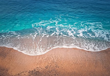 Téléchargez les photos : Des vagues bleues frappent le rivage. Belle texture d'eau de mer turquoise et plage de sable doré. Tropical été fond de mer - en image libre de droit