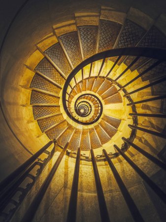 Spiral staircase abstract perspective with view downstairs to infinity swirl stairs in glowing yellow light Poster 651157648