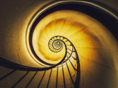 Spiral stairway abstract swirl hypnotising perspective. View downstairs to infinity circular stairs glowing in yellow light background Poster #651157650