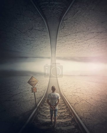 Foto de Concepto de camino infinito con un hombre caminando por el ferrocarril hacia el mundo paralelo de arriba. Escena surrealista y misteriosa, viaje de aventura por el camino sin fin - Imagen libre de derechos