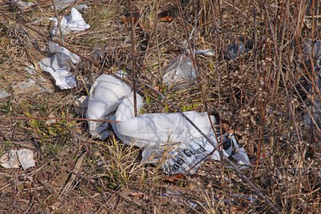 Photo for Trash discarded along a grassy area alongside an (unseen) urban creek . - Royalty Free Image