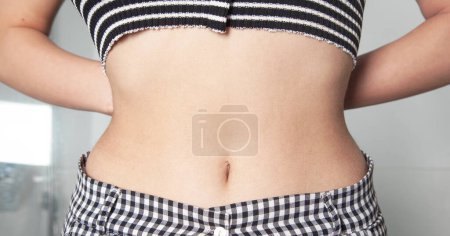 Téléchargez les photos : Jeune femme montrant son ventre. - en image libre de droit