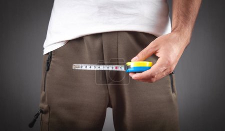 Foto de Man with a measuring tape measures his penis size. - Imagen libre de derechos