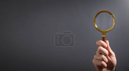 Caucasian businessman holding magnifying glass. 