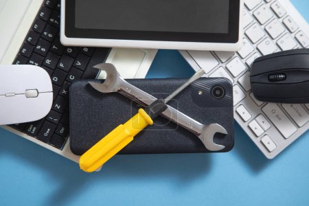 Wrench and screwdriver with a computer keyboard, smartphone, tablet, mouse. IT Service. Support