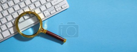 Téléchargez les photos : Loupe de verre sur le clavier de l'ordinateur. - en image libre de droit