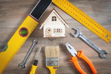 Photo for Work tools with a wooden house model. - Royalty Free Image