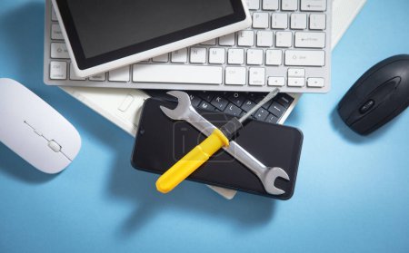 Photo for Wrench and screwdriver with a computer keyboard, smartphone, tablet, mouse. IT Service. Support - Royalty Free Image