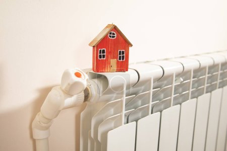 Téléchargez les photos : Modèle de maison sur le radiateur de chauffage. - en image libre de droit