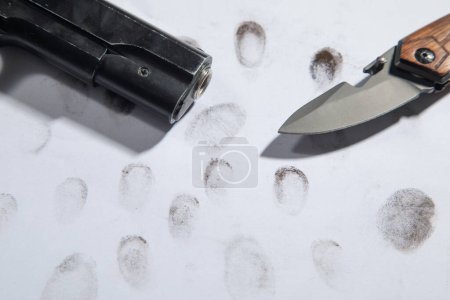 Photo for Pistol and knife on fingerprints ID for criminal. - Royalty Free Image