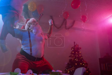 Photo for Fat santa claus dancing crazy in a room - Royalty Free Image