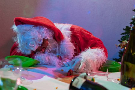 Téléchargez les photos : Ivre père Noël claus dormir sur désordre table - en image libre de droit
