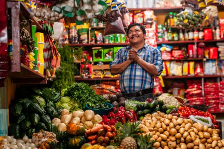 Photo for Food bazaar in Guatemala, happy latin-american man selling vegetables and fruits - Royalty Free Image