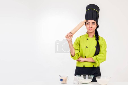 Photo for Latin chef woman, holding a rolling pin thinking - Royalty Free Image