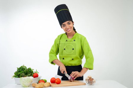 Foto de Portrait of chef cutting vegetables and smiling at camera - Imagen libre de derechos