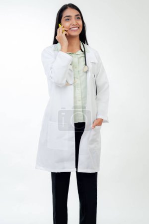 Téléchargez les photos : Female doctor talking on phone, standing on white background - en image libre de droit