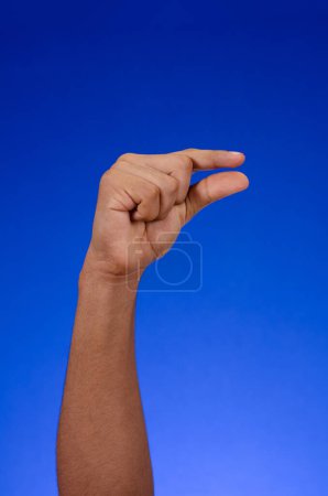 Téléchargez les photos : Hand making symbol or fingers signal, on a blue background - en image libre de droit