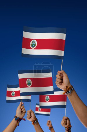 Foto de Grupo de jóvenes con banderas de Costa Rica sobre fondo azul - Imagen libre de derechos