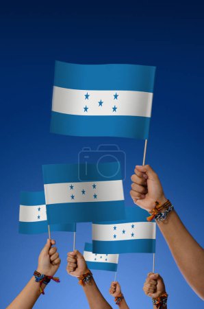 Foto de Grupo de jóvenes con banderas de Honduras sobre fondo azul - Imagen libre de derechos