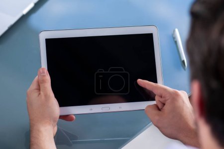 Téléchargez les photos : Homme tenant un ordinateur tablette dans ses mains - en image libre de droit