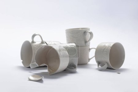 Foto de Set de tazas de porcelana rotas sobre fondo blanco - Imagen libre de derechos