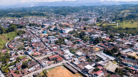 Photo for Aerial view of a town in Latin America, surrounded by forests and mountains. - Royalty Free Image