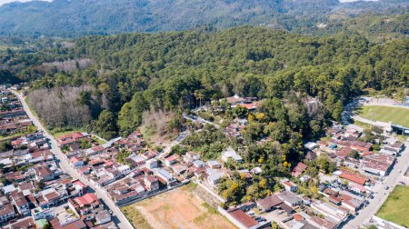 Foto de Vista aérea de un pueblo de América Latina, rodeado de bosques y montañas. - Imagen libre de derechos