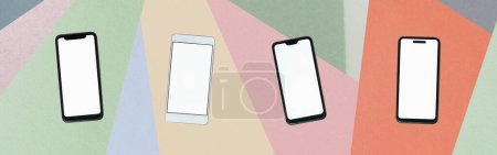 Foto de Teléfonos móviles con pantallas en blanco contra fondo abstracto texturizado en papel. Teléfonos inteligentes, comunicación, aplicación de teléfono y concepto de diversidad - Imagen libre de derechos