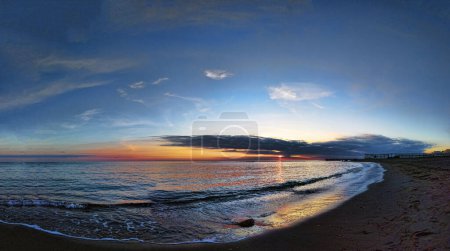 Photo for Amazing and immersive sunset at Rome coast with orange and blue pastel color sky and reflections up sea water, relaxing landscape - Royalty Free Image