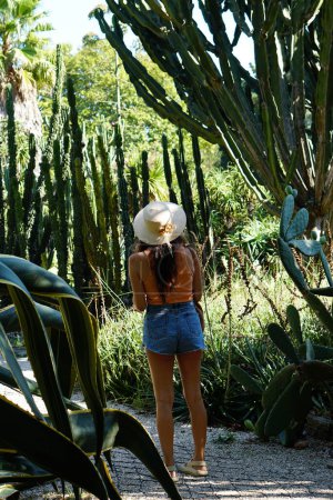 Téléchargez les photos : Femme en chapeau d'été au jardin botanique avec des arbres. été nature - en image libre de droit