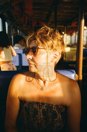 Téléchargez les photos : Portrait de femme dans le bateau, rayon de soleil couchant, heure d'or - en image libre de droit