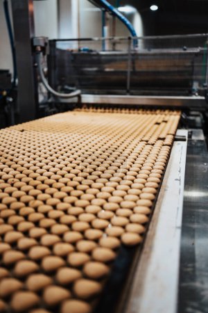 Foto de Enorme línea de fábrica para la producción de dulces y galletas. Primeros planos del proceso de fabricación industrial. - Imagen libre de derechos