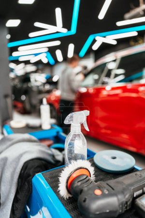 Photo for Professional vehicle polishing and detailing service in a modern car workshop. Brightly lit workspace with large led lights. High quality car valeting concept. - Royalty Free Image