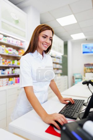 Photo for Beautiful pharmacist working and standing in a drug store and doing a stock take. Portrait of a positive healthcare worker or a chemist at his work. - Royalty Free Image