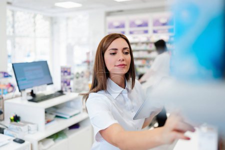 Photo for Two beautiful pharmacists working together in a drug store and doing a stock take. Portrait of a positive healthcare workers or a chemists at their work. - Royalty Free Image