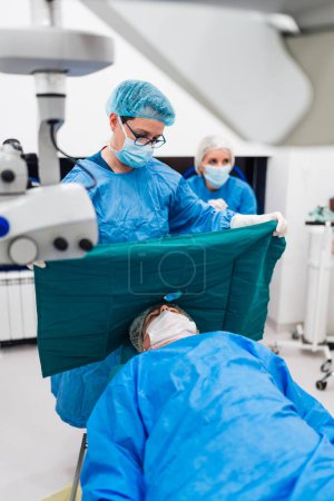 Photo for Skilled female surgeon and his medical team performs precise eye surgery on an elderly patient, restoring vision with latest medical technology and cutting-edge techniques. Modern eye surgery concept. - Royalty Free Image