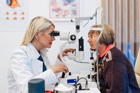 Photo for Beautiful female doctor ophthalmologist is checking the eye vision of senior woman in a modern clinic. Doctor and patient during medical check up in ophthalmology clinic. - Royalty Free Image