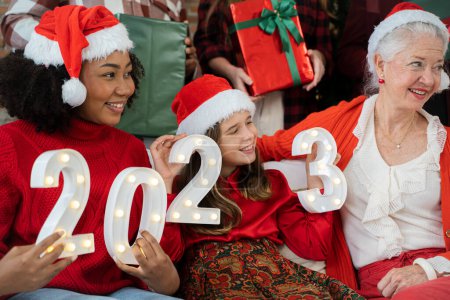 Téléchargez les photos : Heureuse famille célébrant Noël ensemble à la maison - en image libre de droit