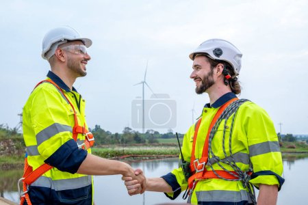 Téléchargez les photos : Poignée de main des ingénieurs après les travaux d'inspection dans la centrale éolienne. - en image libre de droit