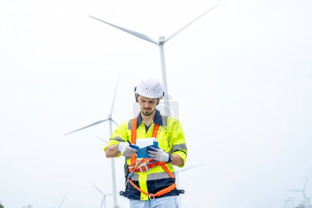 Téléchargez les photos : Technicien d'entretien travaillant dans un parc d'éoliennes, Exploitation d'éoliennes qui transforment l'énergie éolienne en électricité, Le concept d'énergie propre sauve le monde. - en image libre de droit