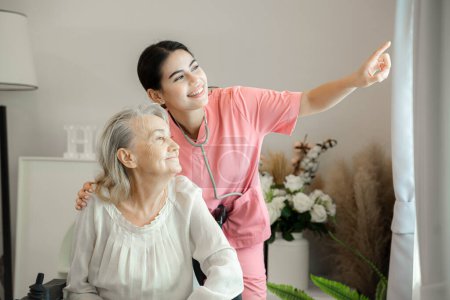 Téléchargez les photos : Infirmière amicale soutenant une dame âgée, profitant d'un moment paisible de détente ensemble. - en image libre de droit