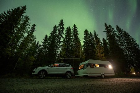Foto de Aurora brillando sobre Camping Caravan en el paisaje forestal sueco Tannforsen Waterfall Northern Lights color cielo norte de Suecia, Escandinavia. - Imagen libre de derechos