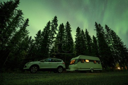 Téléchargez les photos : Aurora brille sur Camping Caravane dans le paysage forestier suédois Cascade de Tannforsen aurores boréales ciel de couleur Suède du Nord, Scandinavie. - en image libre de droit