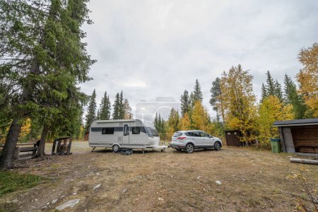 Téléchargez les photos : Caravane de camping près de la rivière coulant vers le lac Gautstraesk et surplombant le paysage automnal le long du parc national Ammarnas en Laponie Suède - en image libre de droit