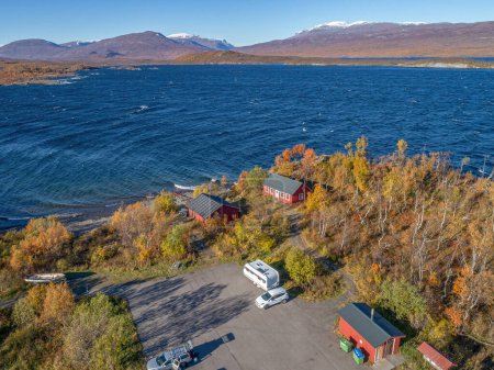 Photo for Aerial footage Car Camping Caravan parking by lake from Abisko national park towards Bjoerkliden during swedish lapland fall colors ruska indian summer - Royalty Free Image