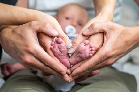 Téléchargez les photos : Doux nouveau-né famille formant bébé pieds coeur bébés pieds dans maman et papa parents mains couleur sélective. - en image libre de droit