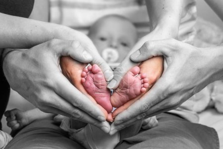 Foto de Dulce recién nacido familia formando bebé pies corazón babys pies en mamá y papá padres manos color selectivo. - Imagen libre de derechos