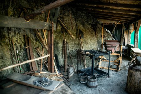 Photo for View of traditional blacksmiths shop for forging medieval iron, with furnace and an ancient bellows blower. - Royalty Free Image